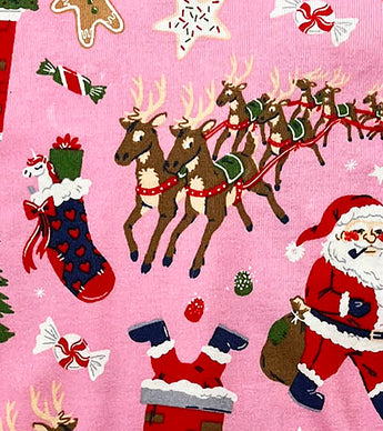 Detail of reindeer, Santa, and candy illustrations on pink kids pajamas