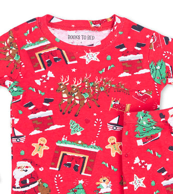 Close-up of red pajama top with Santa, reindeer, fireplace, and Christmas tree designs