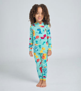 Child wearing dinosaur-themed pajama set with playful illustrations
