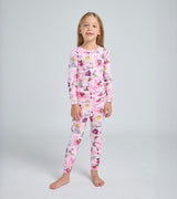 Child wearing pink Twinkle fairy pajama set with playful storybook print