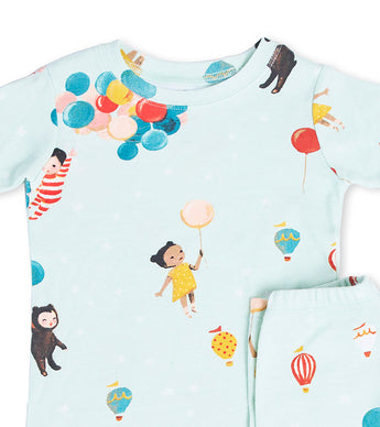 Close-up of pajama top and pants featuring children and balloons in soft watercolor style