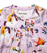 Close-up of Uni the Unicorn nightdress neckline with purple bow and storybook characters