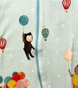 Close-up of coverall fabric featuring illustrated children, balloons, and stars