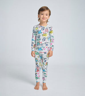 Child wearing The Color Monster pajamas with colorful monster illustrations.