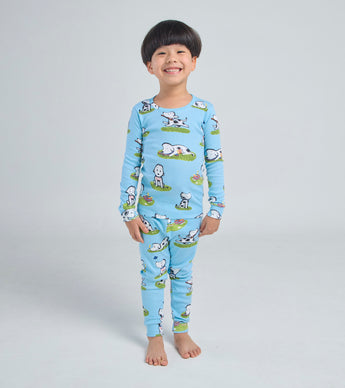 Child wearing blue Rocket dog print pajamas, smiling