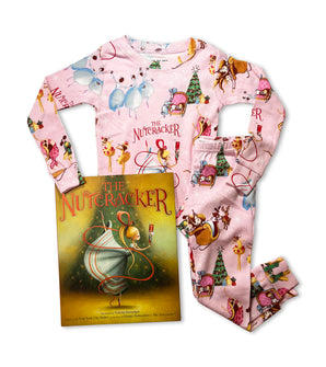 Pink Nutcracker pajama set beside The Nutcracker book; festive ballet-themed print.